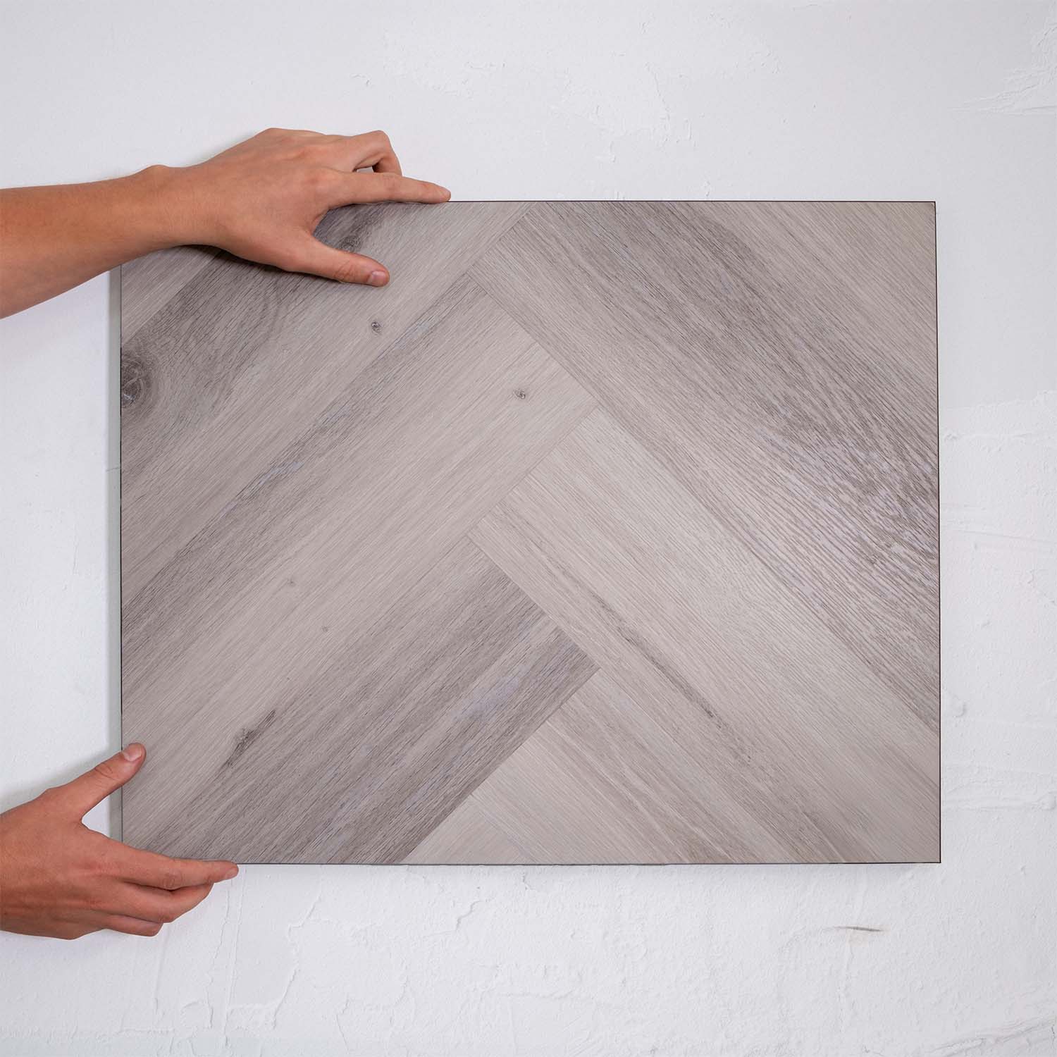 Top-down view of Snow Grey SPC Hybrid Floorboards Herringbone 7.5+2mm in Snow Grey colour light tone herringbone flooring sample